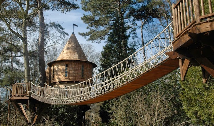 tower-like structures linked together through a bridge, made from rope and wooden planks, diy treehouse, situated in a forest