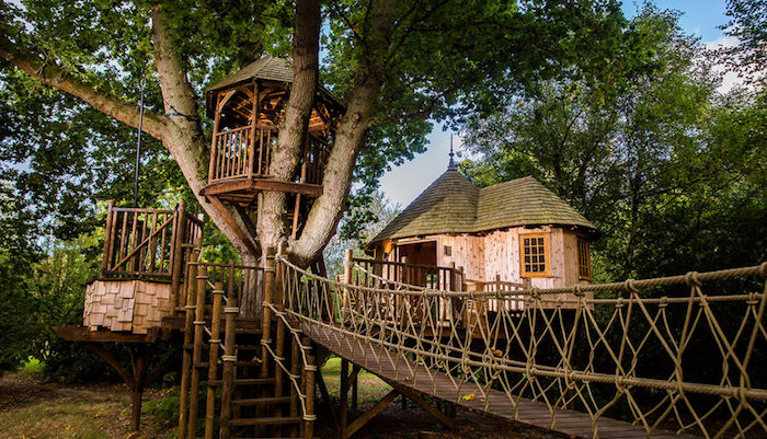 gazebo and a small house, built on green trees, using wood and other materials, and connected by several bridges and stairs, 
