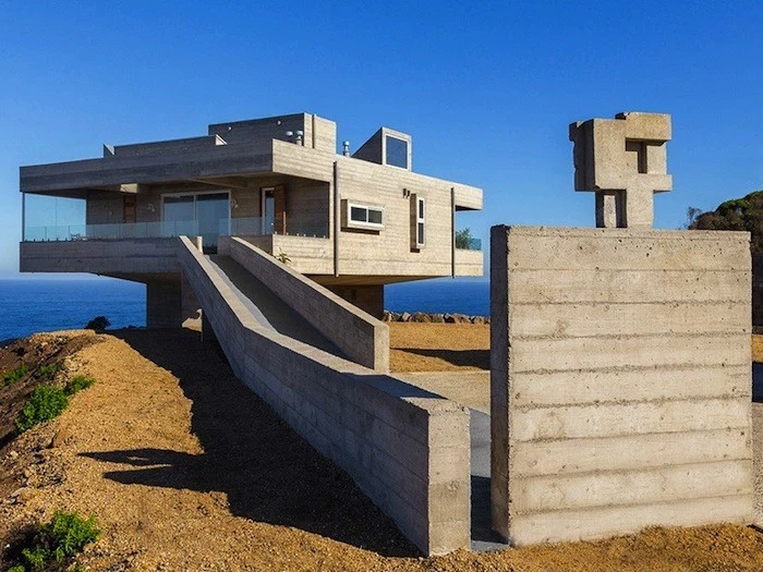 private house in valparaiso chile, situated on a beach, near the sea, and made of pale grey concrete