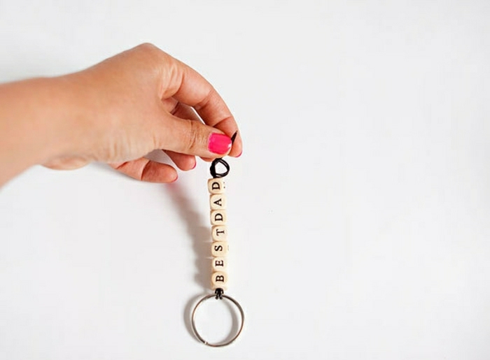 diy father's day gift ideas, a female hand holding a key chain with the message best dad spelled with alphabet beads