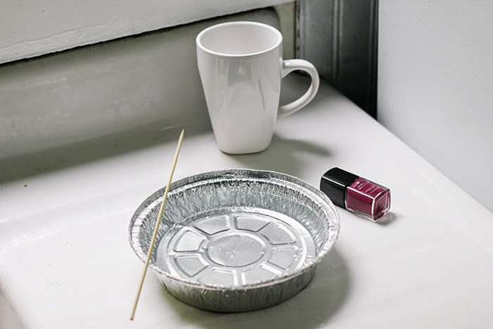 diy gift ideas, white mug placed on a table, near a bottle of dark red nail polish and a tin foil bowl with a wooden skewer