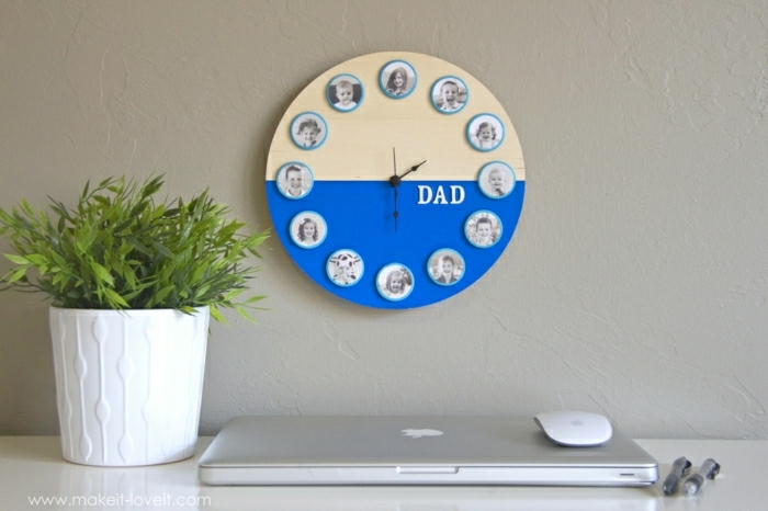 dyi gift ideas, round yellow and blue wall clock with family photos, hanging on a light cream wall, near a potted plant, laptop, mouse and two pens