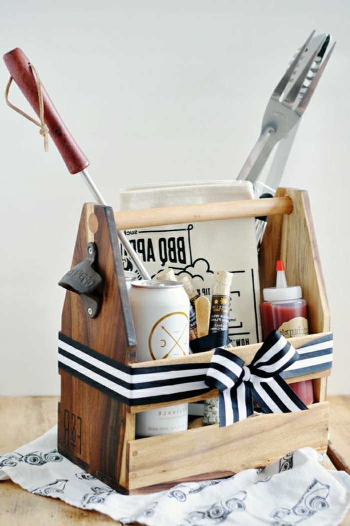 father's day gifts from daughter, tool carrier converted into a barbecue basket, with ketchup, sauces, condiments, beer and grilling tools, on a wooden table with a white background