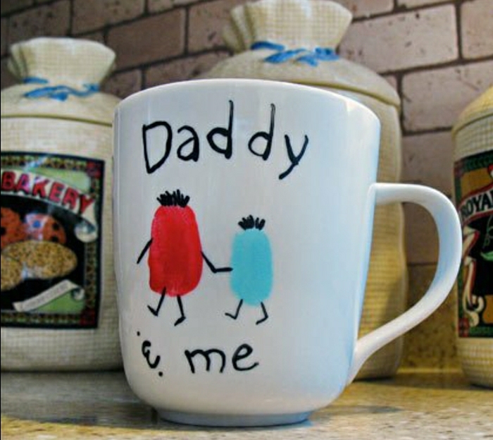  handmade gifts for dad, white hand painted mug with an orange and a blue shape holding hands, a writing saying "Daddy an me", kitchen background