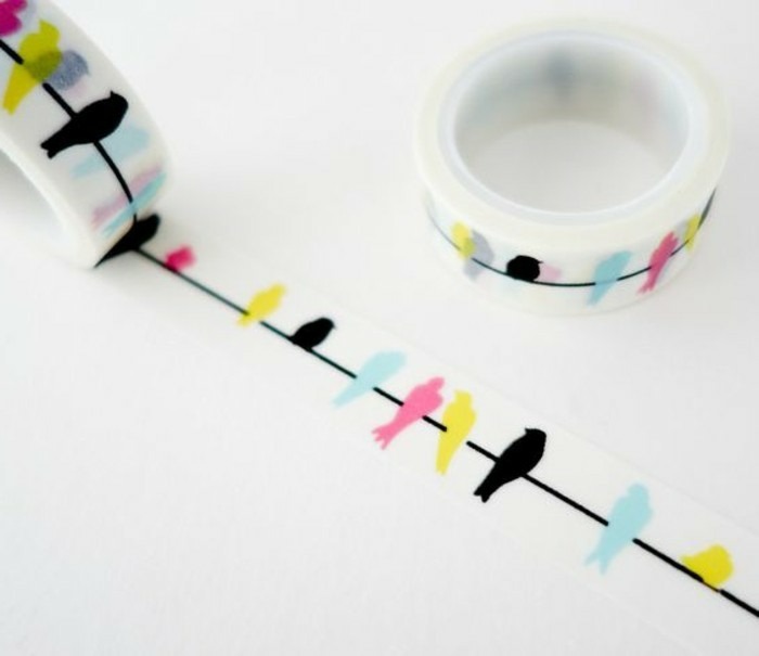 scrapbook ideas for beginners, two rolls of white sticky tape with yellow, black, blue and pink bird design on white background