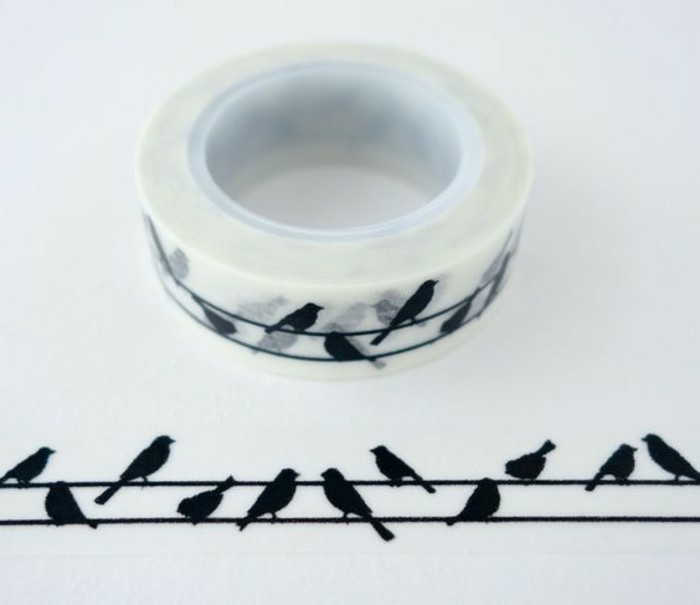 scrapbook ideas for beginners, lightly colored sticky tape with black bird on power lines, one roll on white sheet of paper