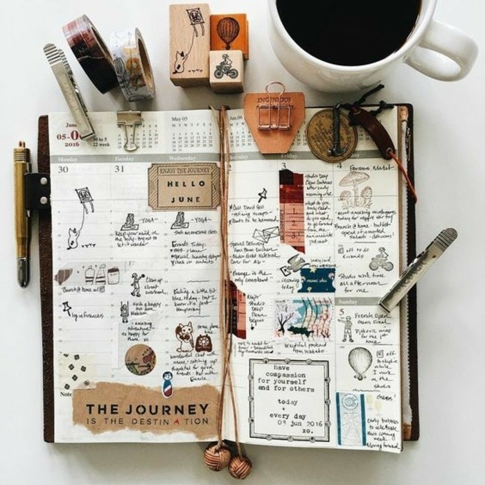 scrapbook ideas, organizer, journal with calendar, dates, months, cutouts, tickets, drawings, writing, near full coffee cup, stationary
