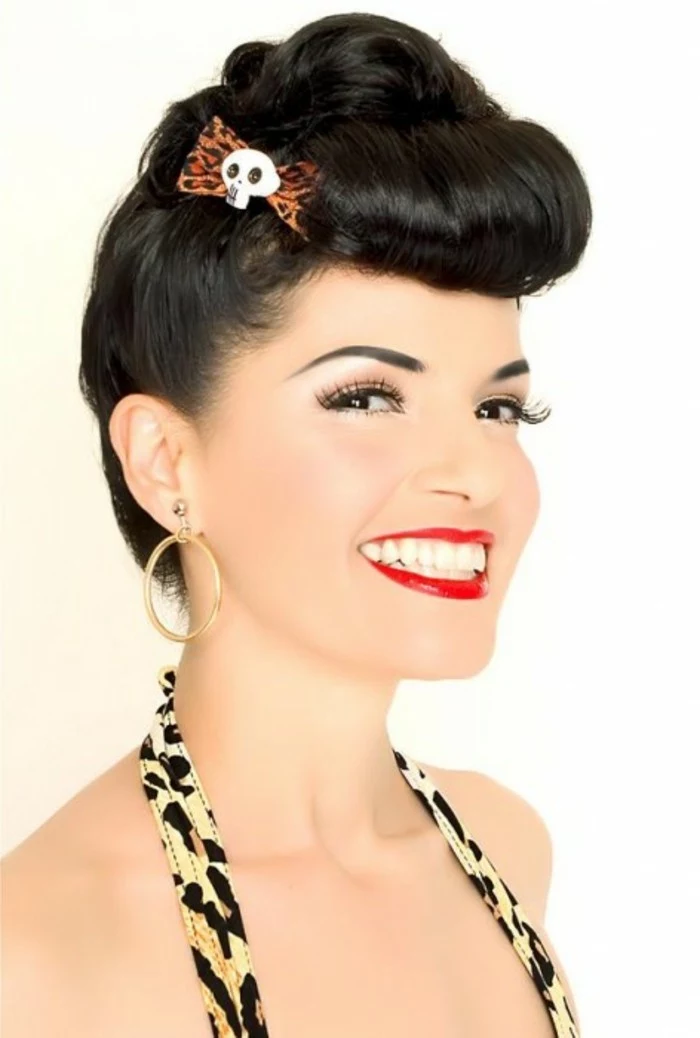 betty bangs, woman with short black hair styled in an updo, animal print bow with skull detail, red lipstick fake lashes big white teeth