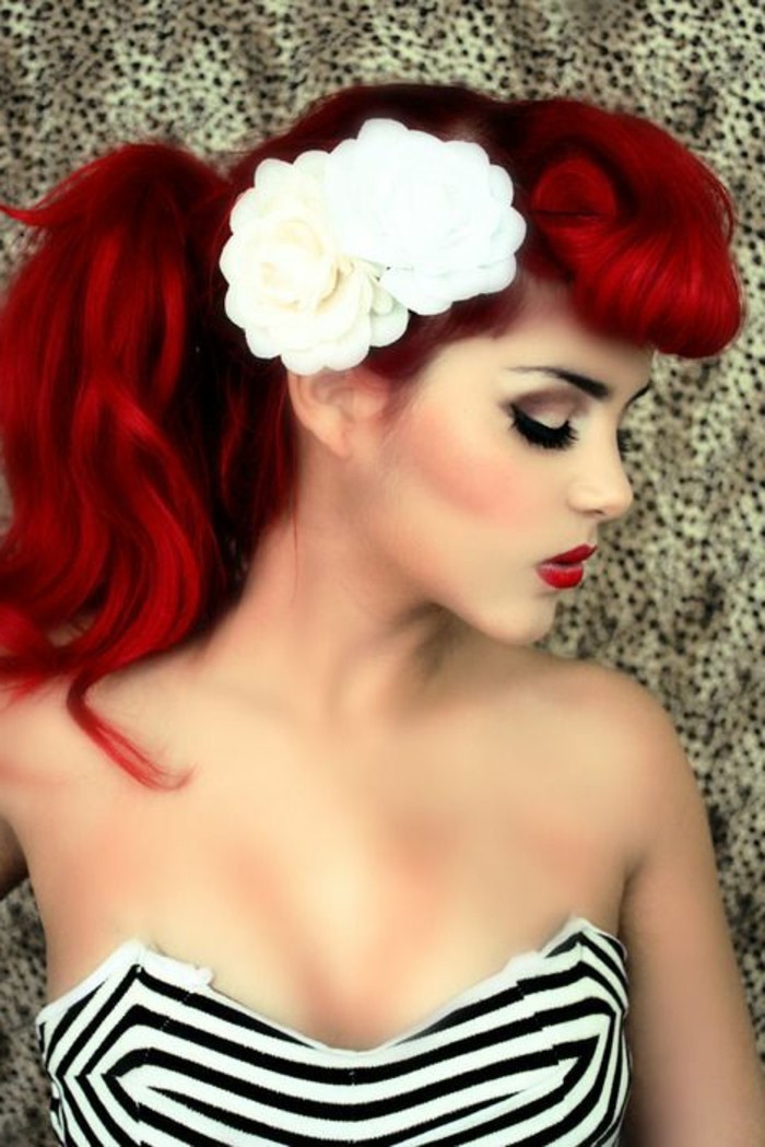 red-haired woman in profile, bettie bangs and ponytail, fake white flower ornaments, heavy make up fake lashes blush, striped strapless top