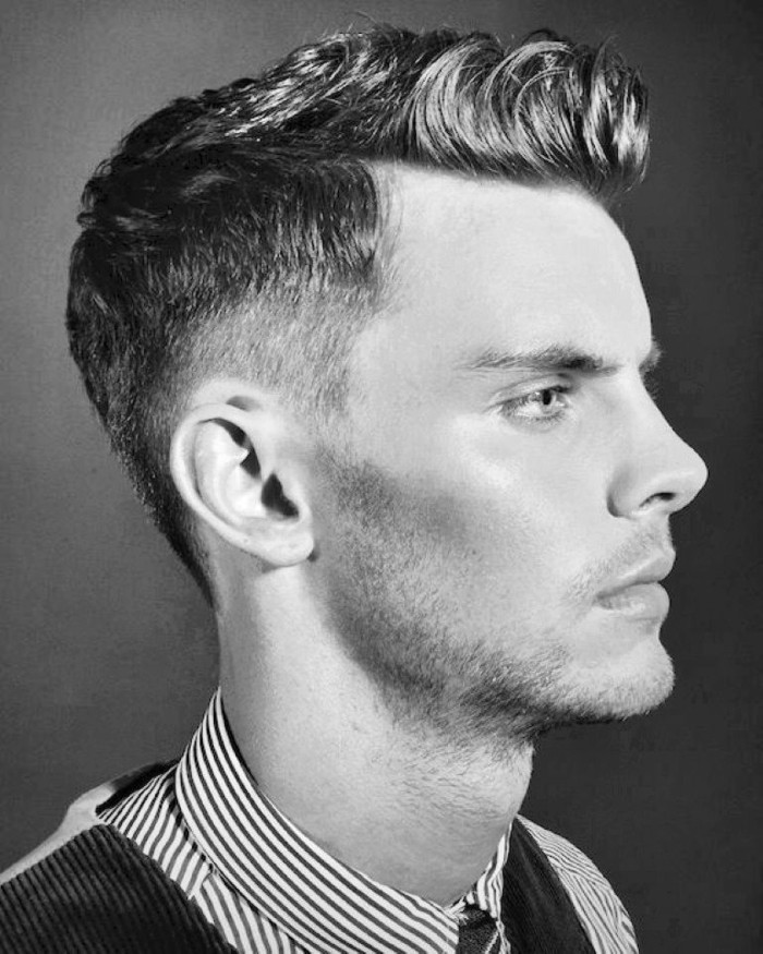 serious-looking young man with short hair and gelled up bangs, in profile with stubbly chin, pinstriped shirt and formal vest, black and white photo