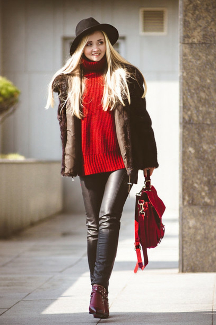 women's business attire, woman with long blond hair, wearing black leather trousers and chunky red sweater, with big leather coat and black hat, purple ankle boots and red bag