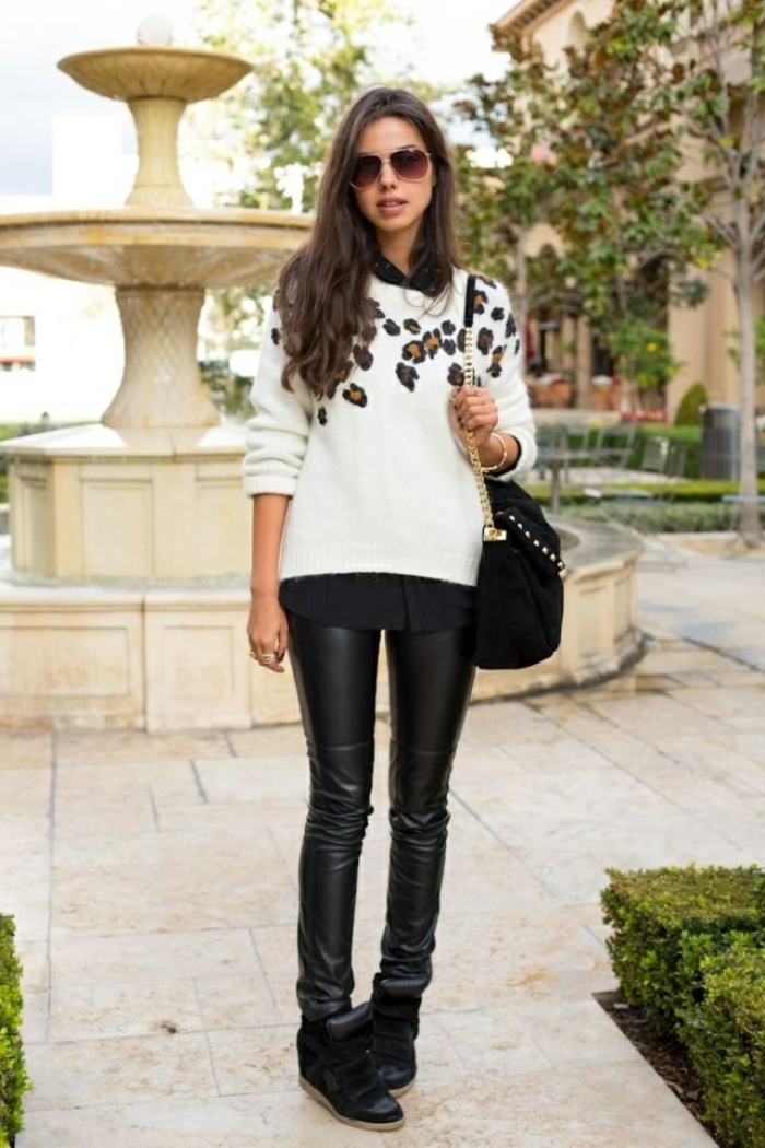 business attire for women, skinny black leather trousers, black shoes and shirt, white sweater with animal print detail, on brunette woman with sunglasses