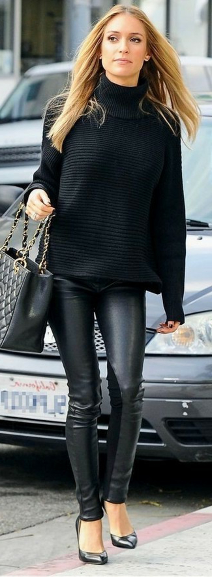 women's business attire, woman wearing black chunky turtleneck sweater, black leather skinny trousers and black high-heels, holding black leather bag