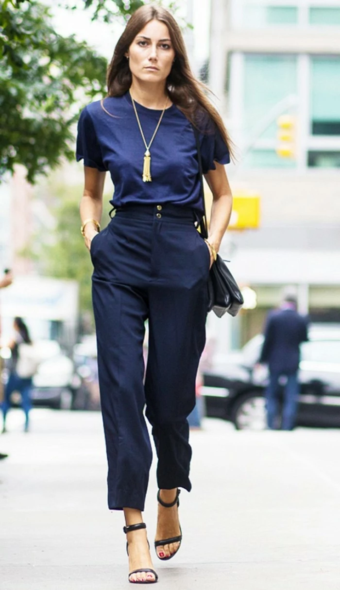 interview outfits for women, serious brunette woman, wearing high-waisted navy trousers, high-heeled sandals and black bag, dark blue t-shirt and golden necklace