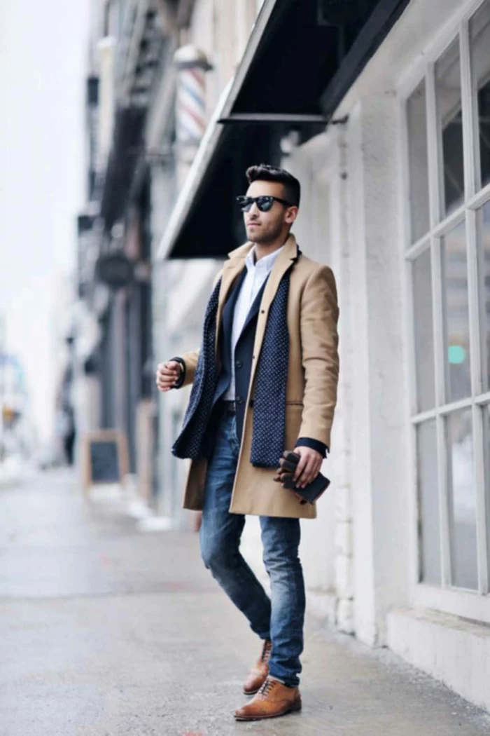 business casual outfits, brown leather shoes, jeans with white shirt and dark navy blazer, camel brown coat and navy scarf, worn by man with sunglasses, holding leather gloves