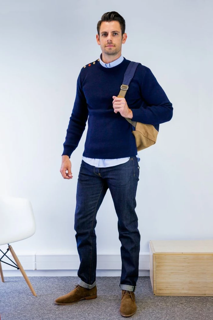 business casual outfits, dark navy sweater over light blue shirt, dark blue jeans and brown leather shoes, worn by man with camel brown backpack