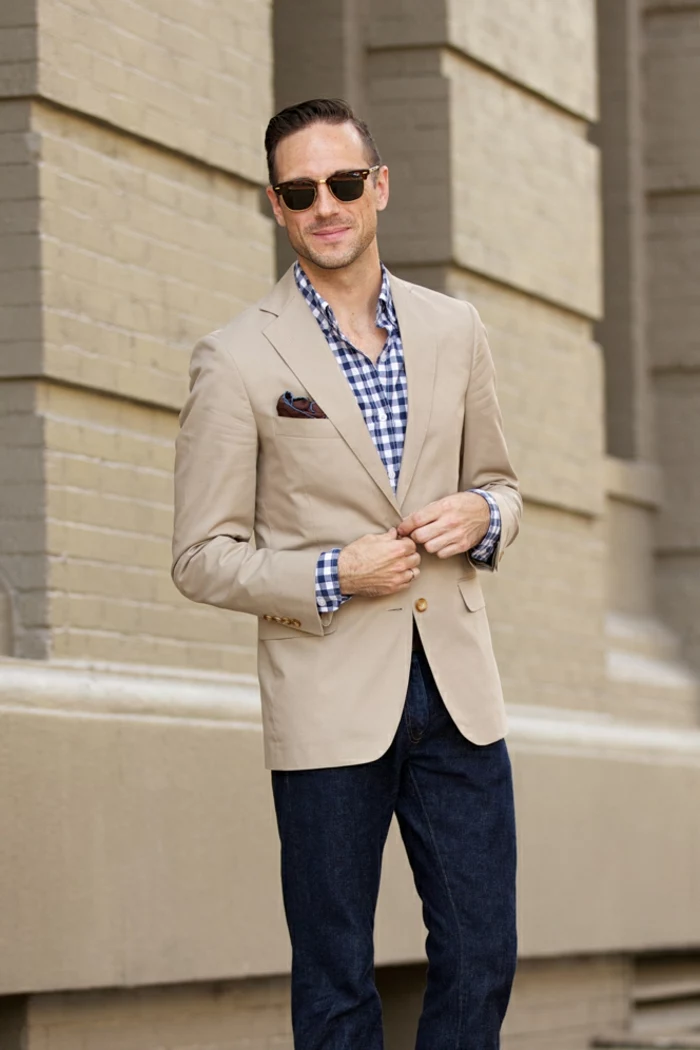 business professional attire, man with gelled back hair, light brown blazer with handkerchief, over white and blue chequered shirt, dark blue jeans and sunglasses