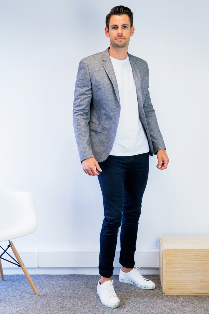 business professional attire, man with slicked back hair, white t-shirt and grey blazer, dark blue trousers and white sneakers