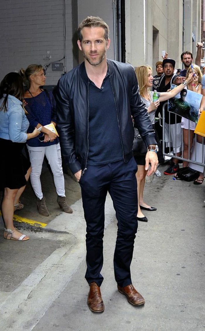 business professional attire, ryan reynolds wearing dark navy pants, black top and black leather jacket, with brown leather shoes