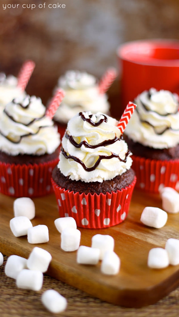 christmas cupcakes, a few chocolate cupcakes, whipped cream frosting with chocolate syrup drizzle, little marshmallows and straw decorations