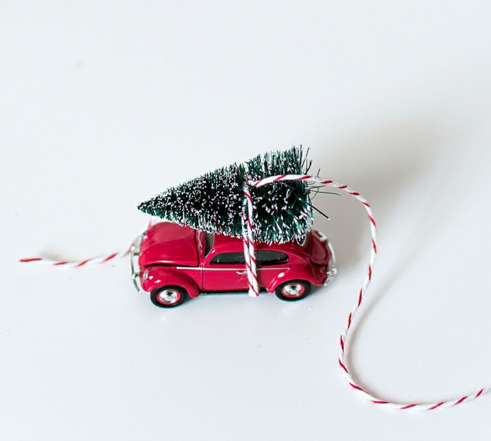 homemade christmas gift ideas, small xmas tree ornament tied to little red car toy with red and white string, white background