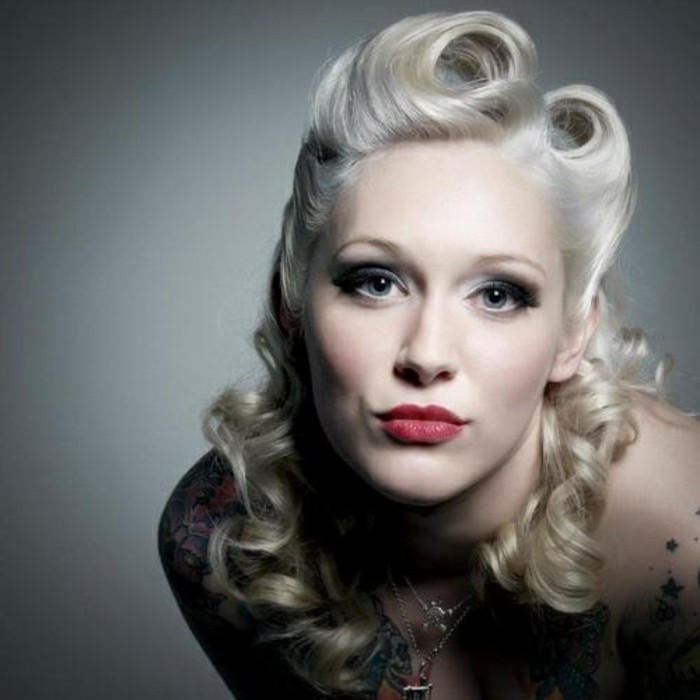 rockabilly hairstyles, pale woman with platinum retro hair, dramatic eye make up and red lipstick, close up with shadows on body and face