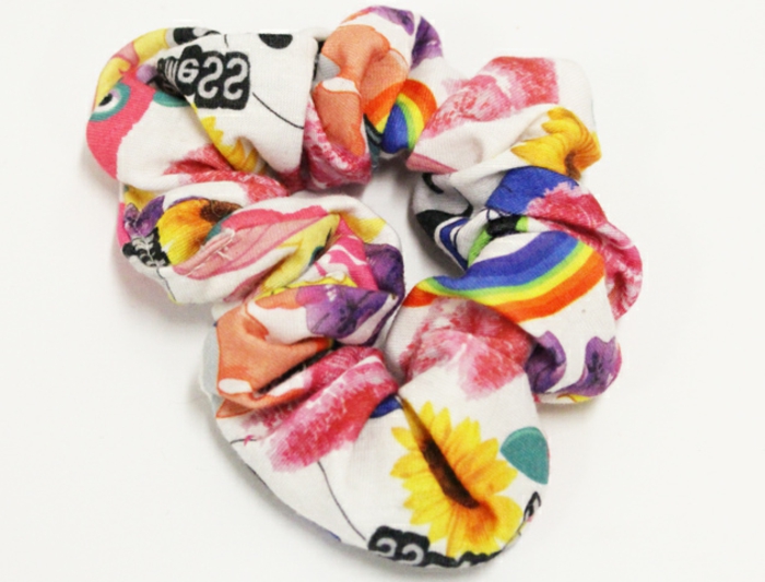 80s clothing, close up of colorful scrunchy, with sunflowers rainbows and writing, on white background