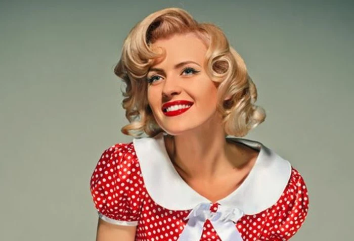 pinup hair, smiling woman with white teeth and red lipstick, wearing red retro dress with white polka dots, white collar and bow and puffy short sleeves, short blonde hair with retro curls