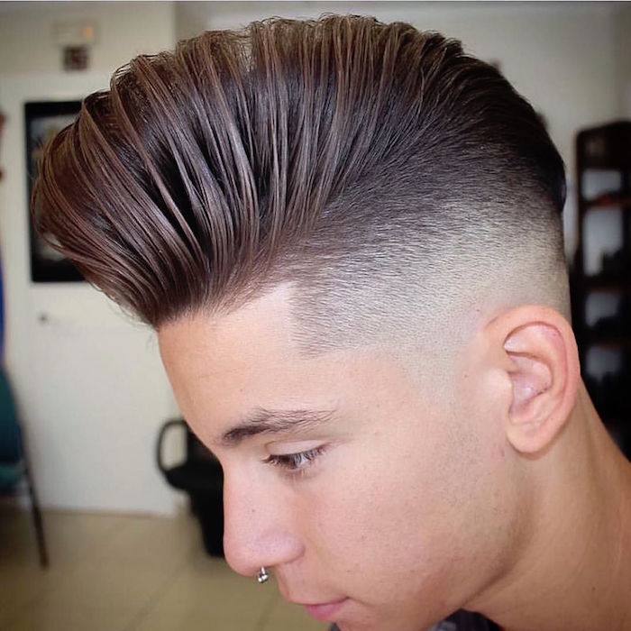 disconnected haircut, boy with nose ring, facing down and sideways, shortly trimmed hair on side, long and styled up on top, comb-over or pompadour style