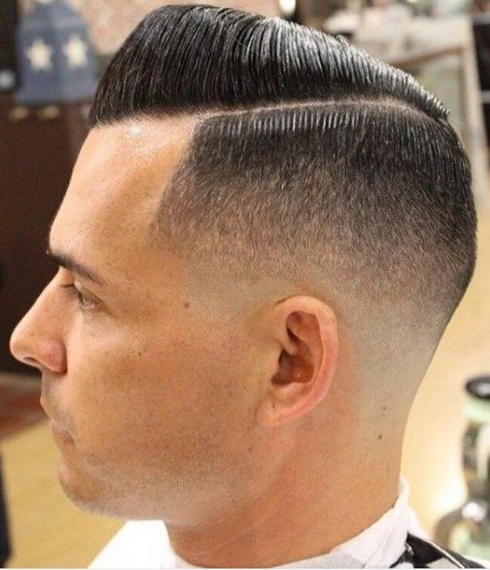 side part undercut, man with dark hair parted on one side, longer on top and combed over with gel, shorted on the sides