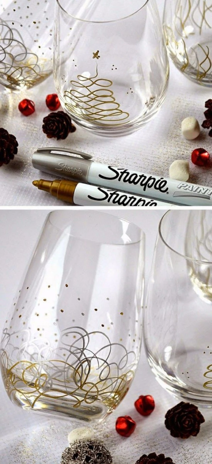 several plain water glasses, decorated with gold and silver permanent markers, abstract Christmas tree drawing and different shapes, little pine cones red and white beads