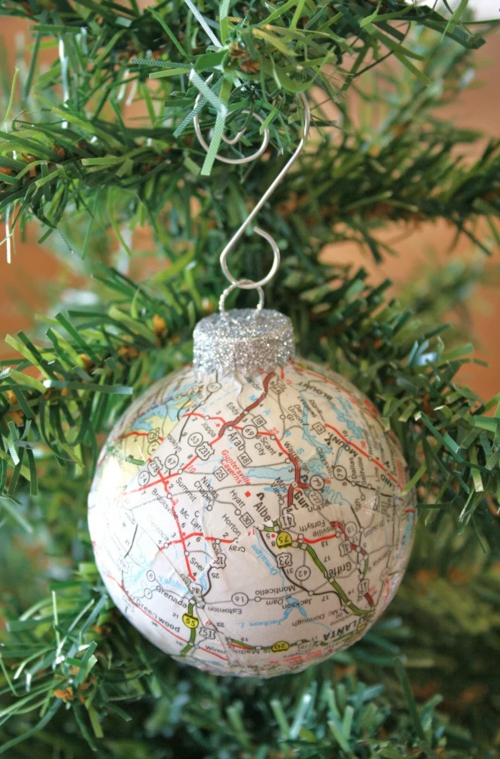 cheap christmas gift ideas, christmas bauble with silver glittering cap, decorated with a map, hanging from an xmas tree on a silver hook