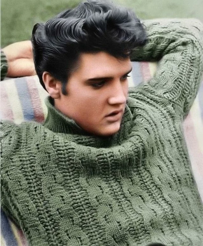 colorized photo of elvis presley, leaning on striped surface, with arms behind head, shiny black wavy gelled up hair, chunky green cable knit turtle neck sweater