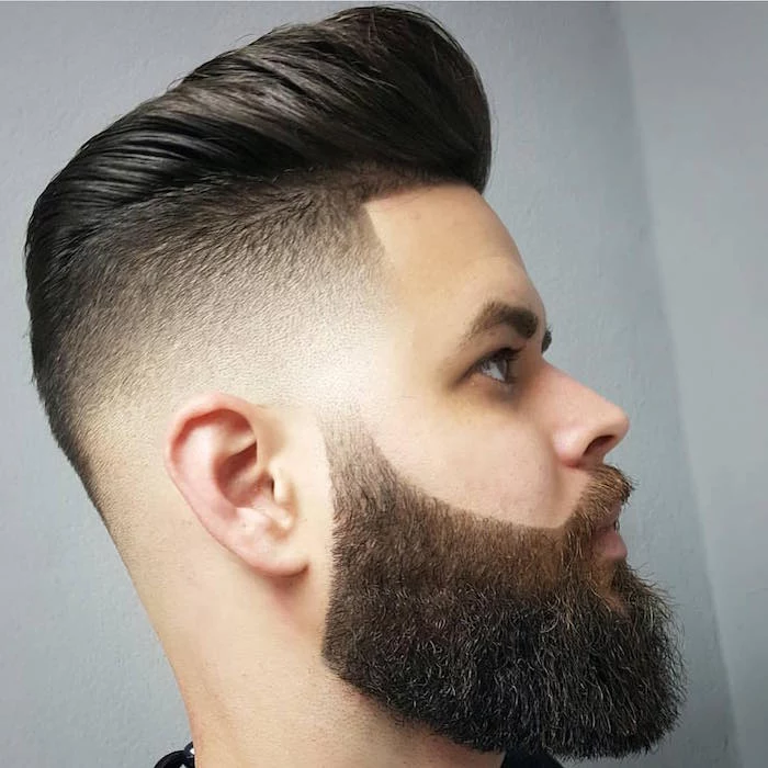 slicked back undercut, pale man with dark hair, facing sideways and in close up, trimmed beard and mustache, very short side hair and puffy pompadour style top hair, brushed back with gel 