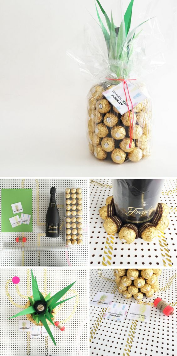 pineapple made of chocolates in golden wrappers, a black champagne bottle, some green and white paper, red thread and a ruler