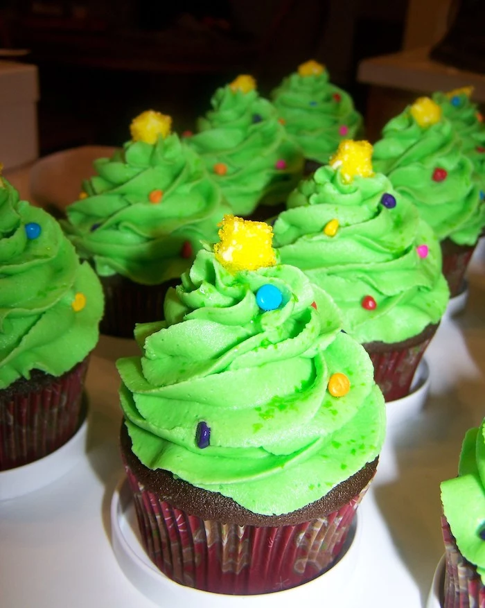 chocolate cupcakes images, batch of chocolate cupcakes, with bright green frosting shaped like x-mas tree, decorated with colorful sprinkles, and small yellow candy stars