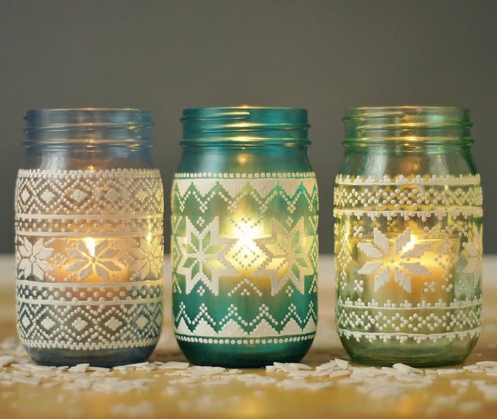 xmas gifts, three white, light blue and yellow mason jars with candles inside, decorated with white 3D drawing,featuring a nordic knit pattern,