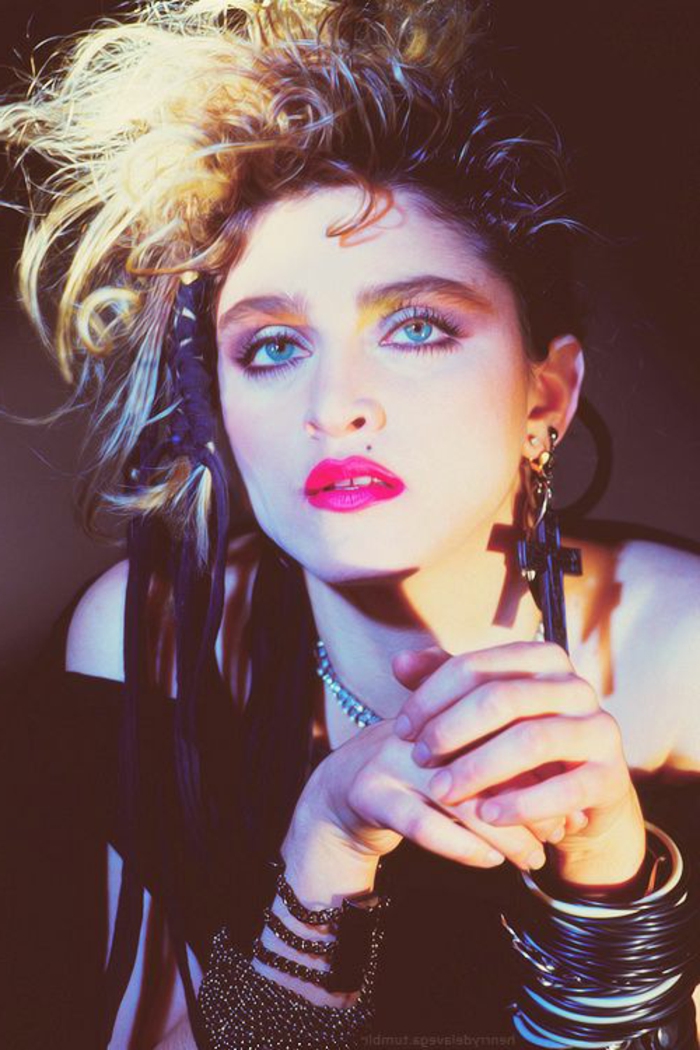 80s fashion, madonna with short messy blond hair, a lot of bangles bracelets and earring with big black cross, hair ornament with purple tassels