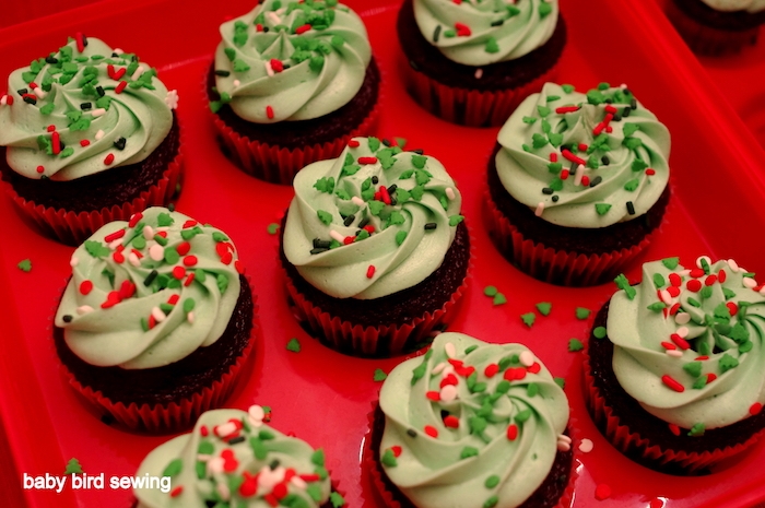chocolate cupcakes images, nine chocolate cupcakes with green icing, decorated with white, green and red sprinkles, on red cupcake mould