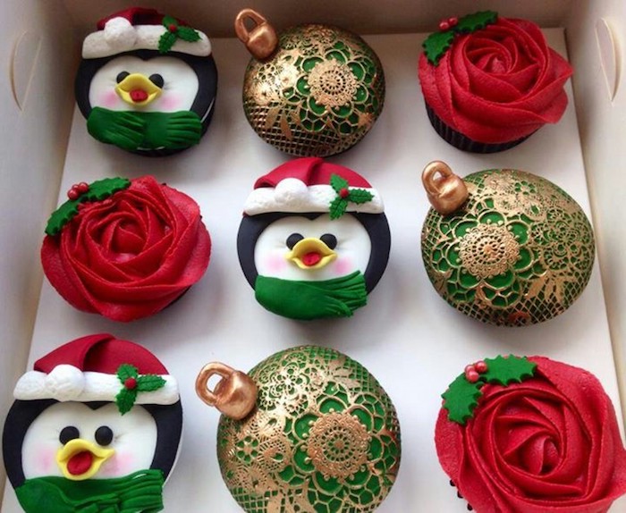 nine cupcakes in white box, three with red icing made to look like a rose, three with colorful icing made to look like penguin, three with green and gold icing made to look like ornaments