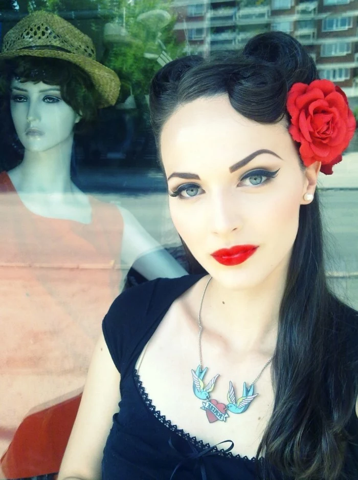 rockabilly hair, woman with very pale skin and heavy make up, bright red lipstick bold black eyeliner and mascara, dyed eyebrows and black hair with victory rolls and a fake red rose