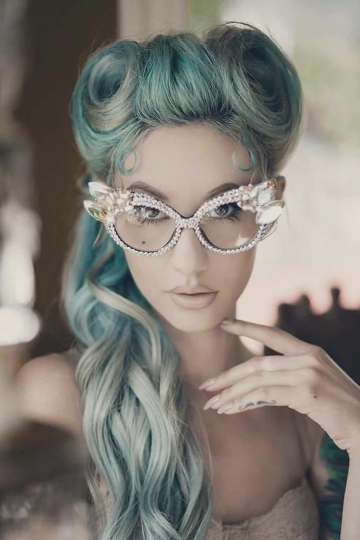 rockabilly hairstyles, woman with long light blue hair victory rolls and curls, wearing decorative glasses with rhinestone studded frames, mustache finger tattoo