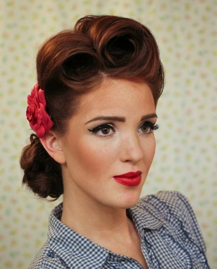pinup style, close up of red-haired woman with freckles, hairdo with victory rolls and fake red flower, bright red lipstick and fake eyelashes, eyeliner and mascara, ruffled chequered shirt