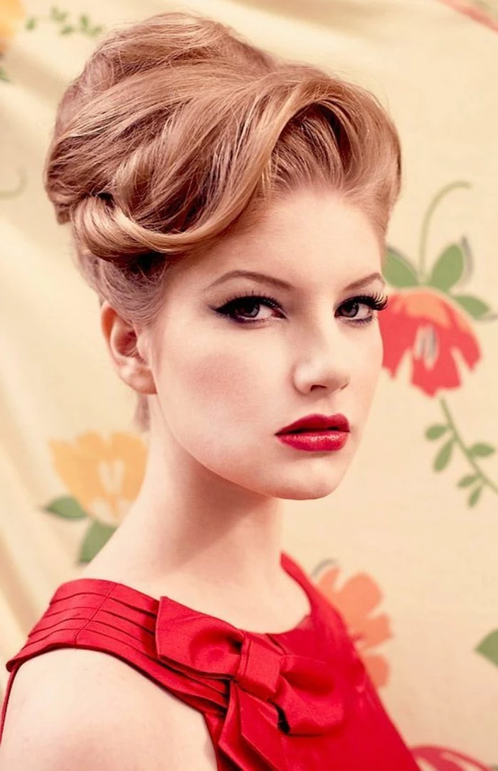 rockabilly hairstyles, close up of a woman with ginger hair in fancy retro 1950's undo, red top with bow, red lipstick fake lashes and eyeliner