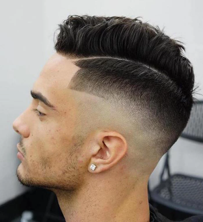 how to style a undercut, young man with dark hair, side parting and short on the side, long wavy and gelled up on top, square diamante earring, stubble on chin and upper lip