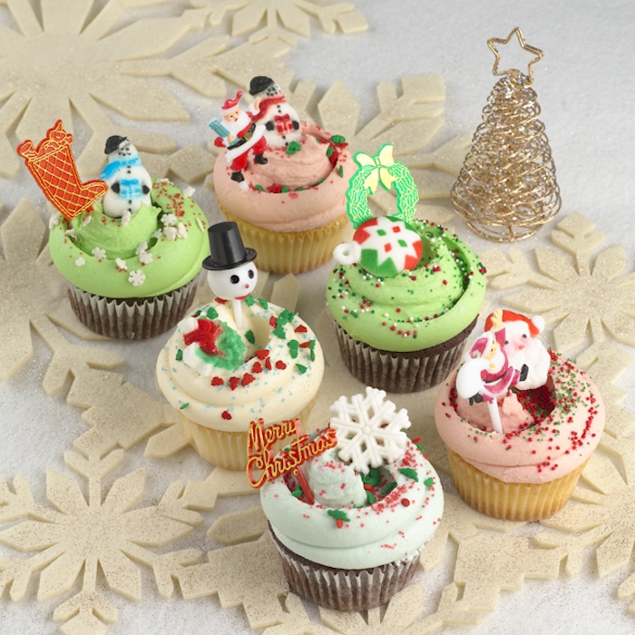 mini cupcake recipes, six chocolate and vanilla cupcakes, with pale blue pale pink and pale green frosting, decorated with christmas-themed shapes, near a small golden christmas tree ornament