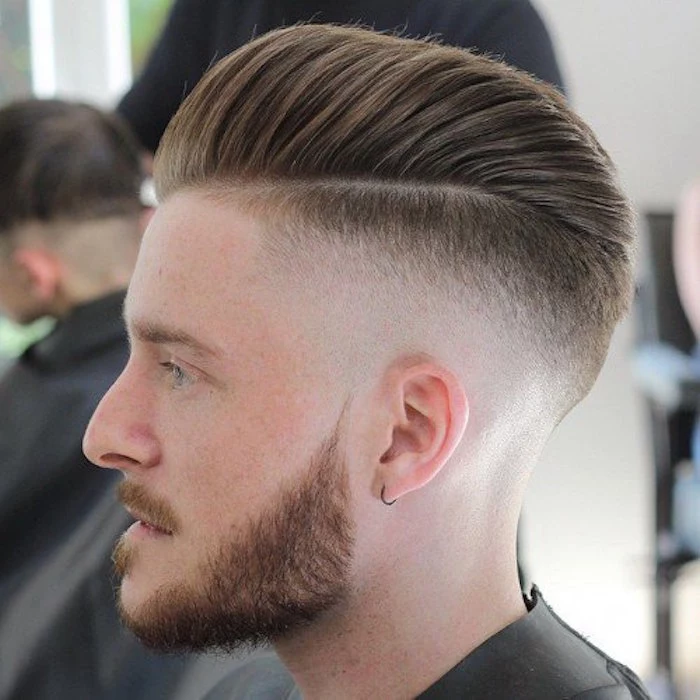 how to style a undercut, close up of a fair-haired man in profile, trimmed beard and mustache, small earring and hair cut short on the side and kept long on top