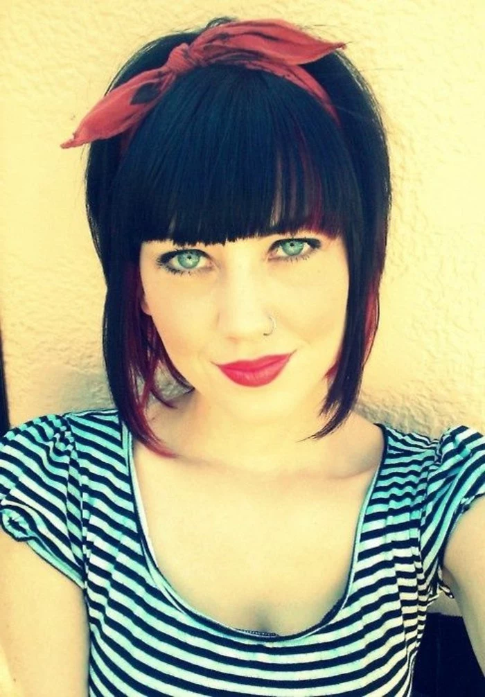 smiling woman with blue eyes and a retro hairstyle, bangs and a red bandanna, wearing a white and black striped top, black eyeliner and mascara yellow filter