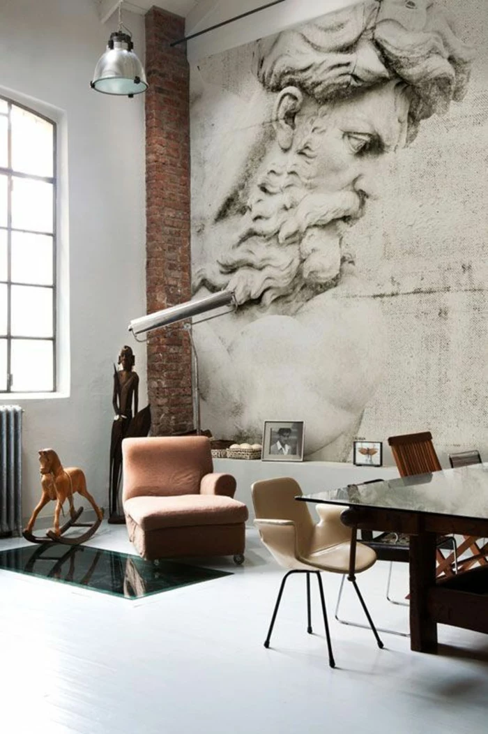 paint colors for living room, white floor and wall, big mural of statue and brick wall detail, wooden african statute and rocking horse, pale brown chair, massive wooden table with glass surfaces, cream chair and window