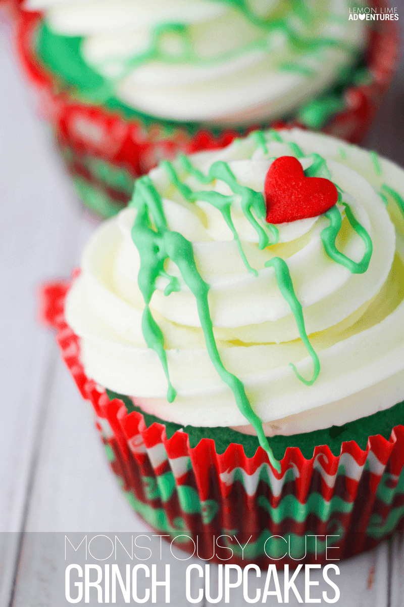 holiday cupcakes, close up of two green cupcakes in red and green wrappers, with white frosting decorated with green drizzle and small red heart